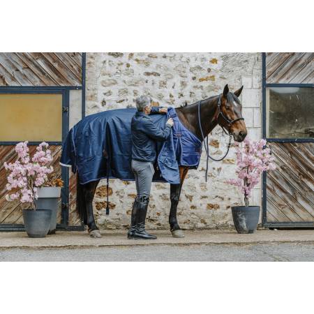 Cavalier mettant la couverture 0 g Classic 1200 D Equithème sur la sous couverture