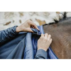 Zoom sur un cavalier accrochant la couverture 50 g Classic 1200 D Equithème à la sous couverture