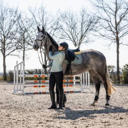 Tapis de selle Florence sauge HKM sur un cheval gris avec cavalière à pied