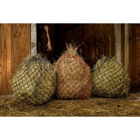 Filets à foin Zari Hippo-Tonic remplis devant le box d'un cheval